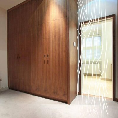 Drewniana szafa wnękowa, która jest przykładem garderoby na wymiar z profesjonalnym doradztwem.