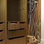 Wnętrze drewnianej szafy z widocznymi szufladami, idealne do projektowania szafy na ubrania na wymiar.